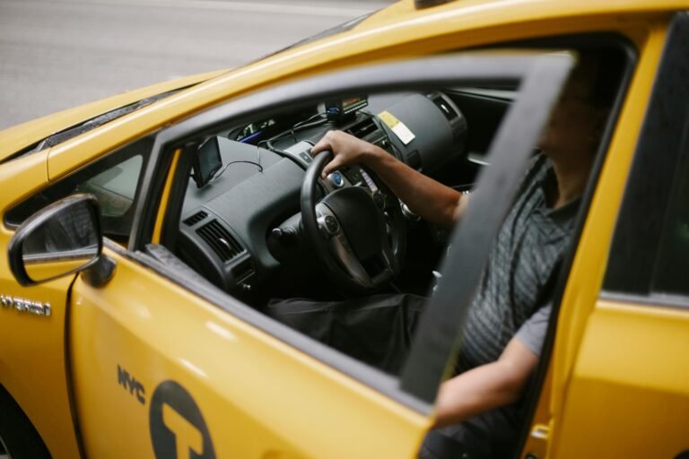 Conductor de taxi manejando vehículo amarillo durante un servicio bajo reserva